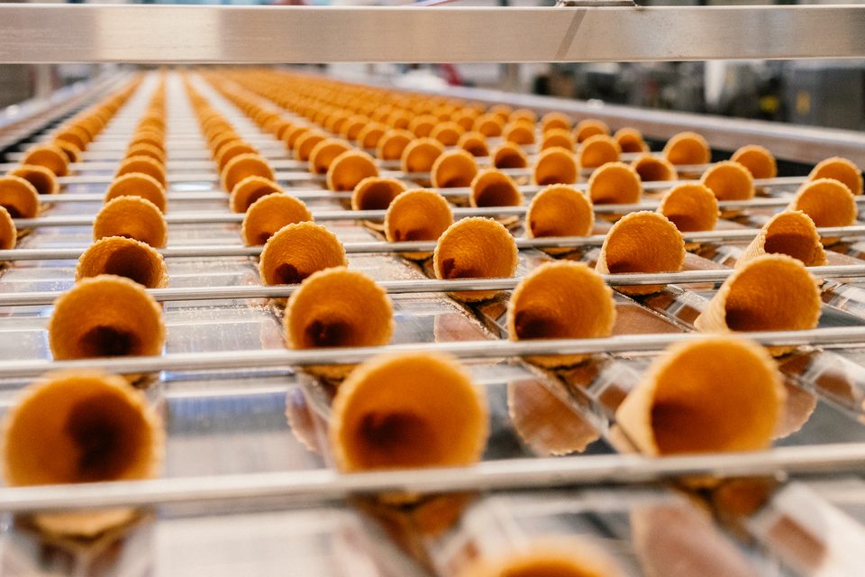 Reihen frisch gebackener Waffelhörnchen laufen über die Linie