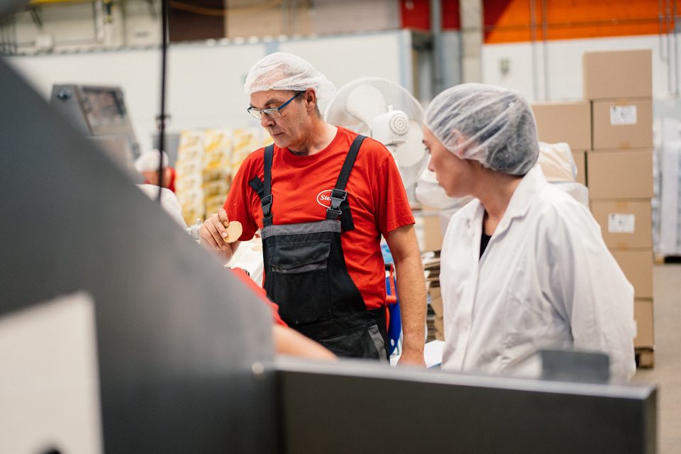 Zwei Kollegen prüfen gemeinsam Waffeln an der Linie