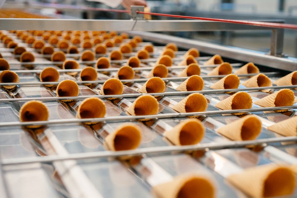 Waffelhörnchen auf dem Band, im Hintergrund eine Hand am Geländer